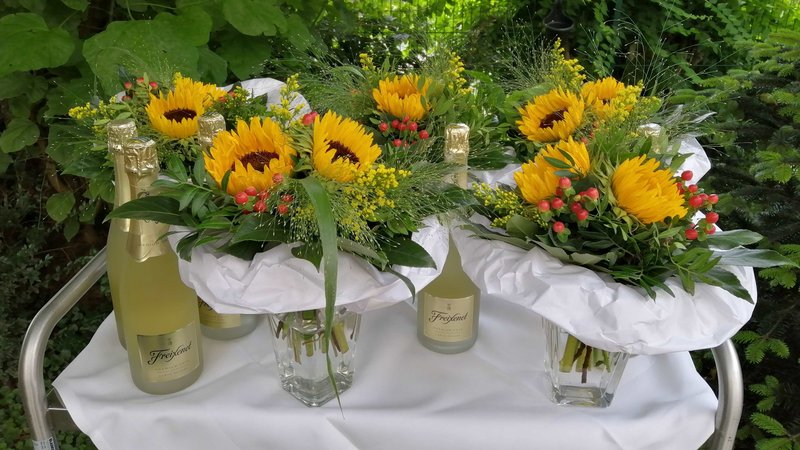 Auf diesen Bild sind Sonnenblumen sowie Sektflaschen zu sehen. Diese dienten als Geschenk für die Jubilare.