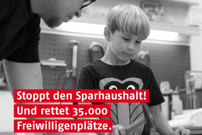 Das Foto zeigt einen jungen, der vom einem Bufdi betreut wird, und den Satz: Stoppt den Sparhaushalt! Und rettet 35.000 Freiwilligenplätze