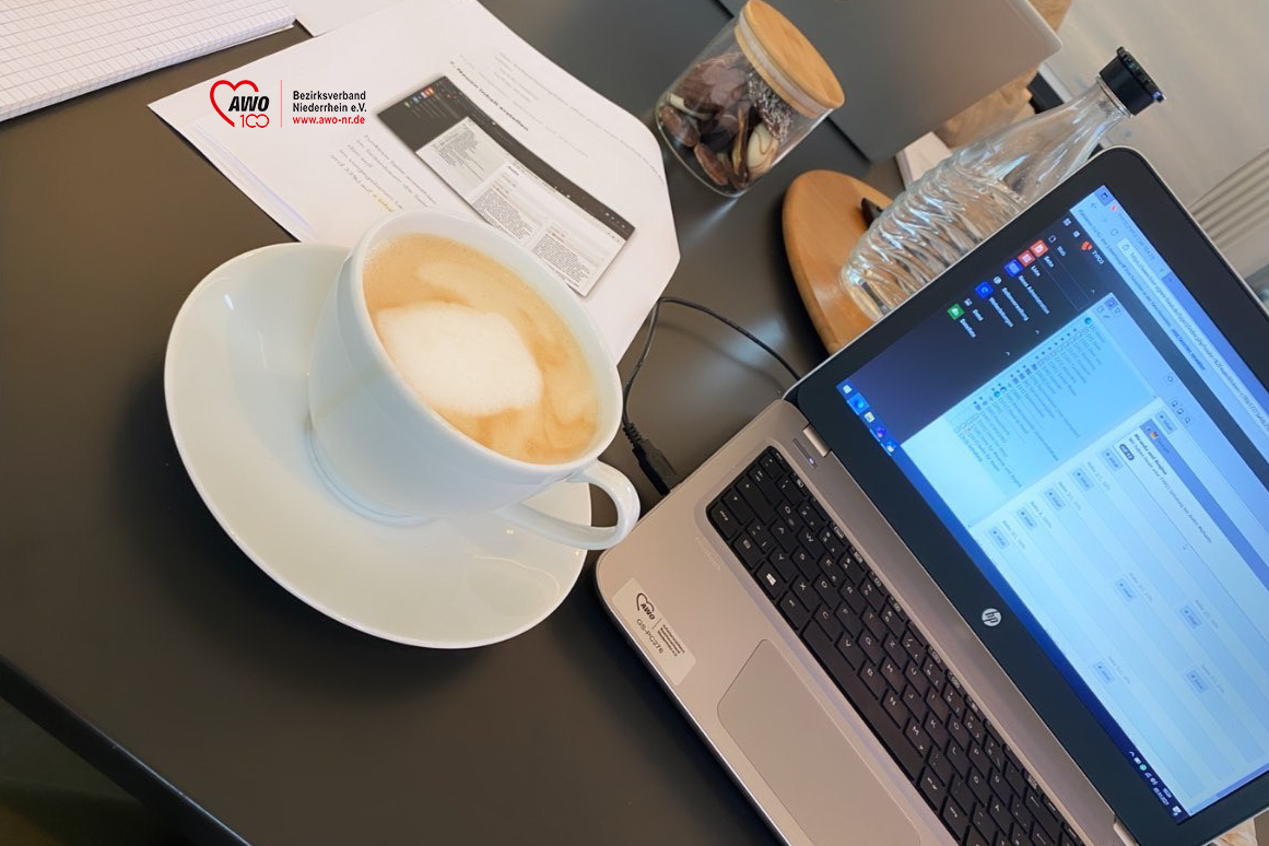 Das Foto zeigt einen Laptop während der Schulung, eine Flasche Wasser und eine Tasse Kaffee.