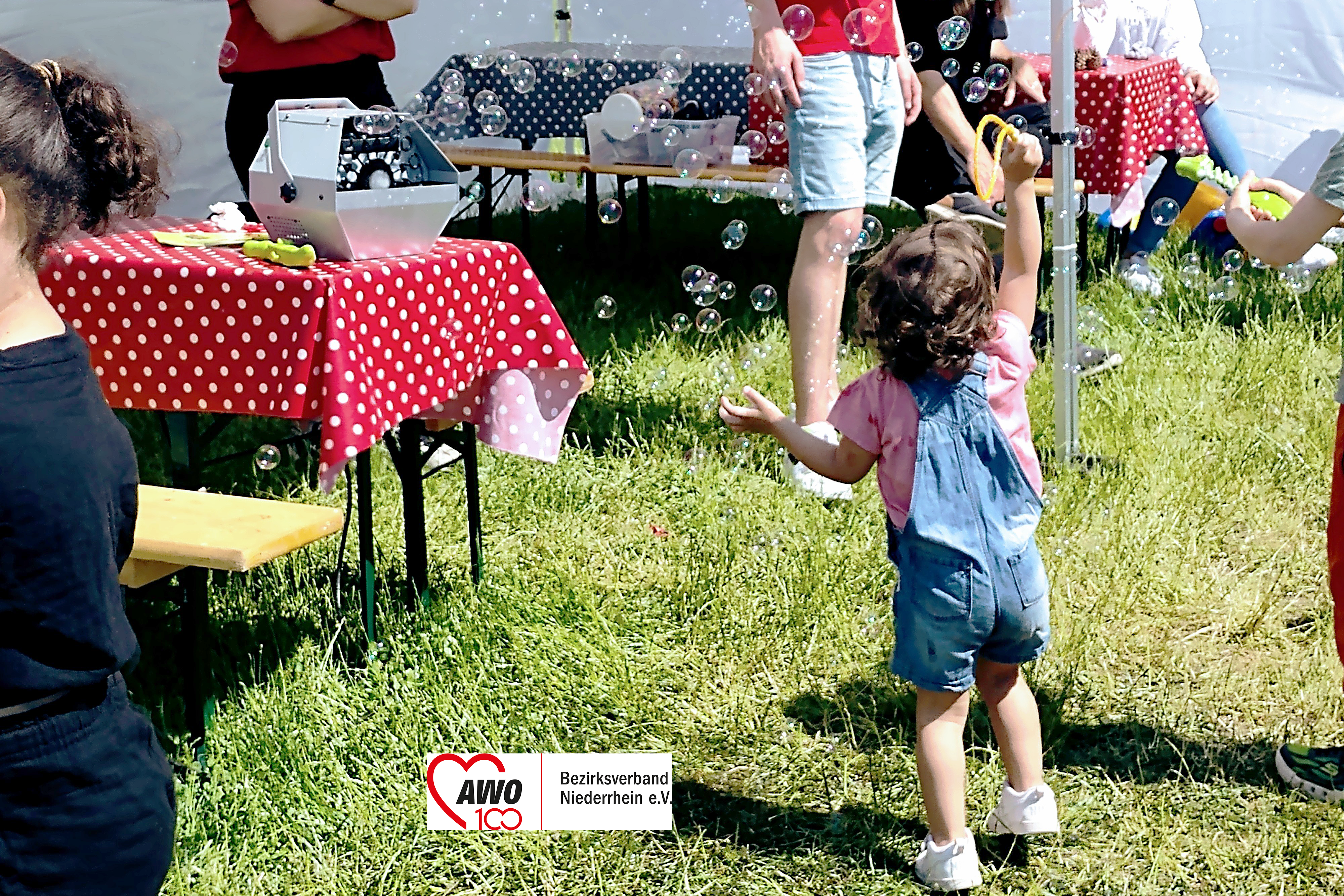 Das Foto zeigt ein Kind beim Spielen mit Seifenblasen auf dem Kindertag.