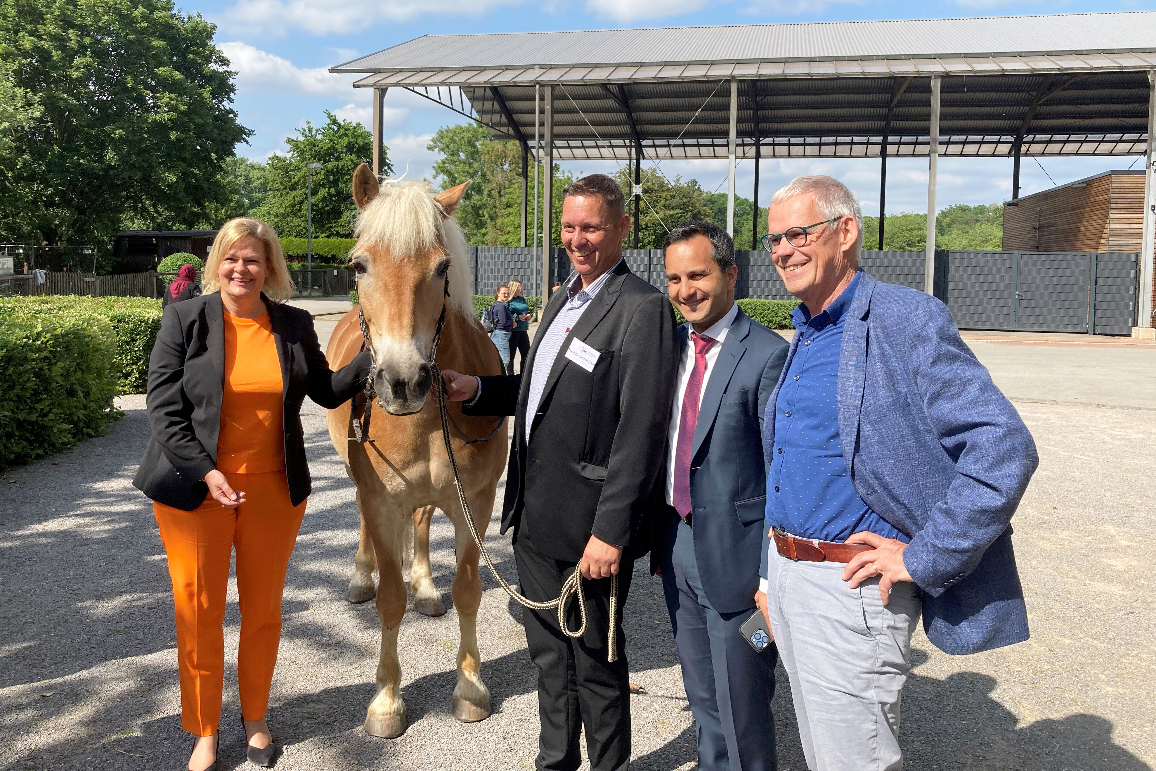Das Foto zeigt Nancy Faeser, Veysel Keser und Jürgen Otto neben einem Pferd.